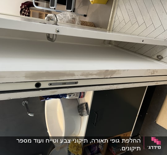 דלת עם מנעול פתוח וכלי עבודה ליד כיור